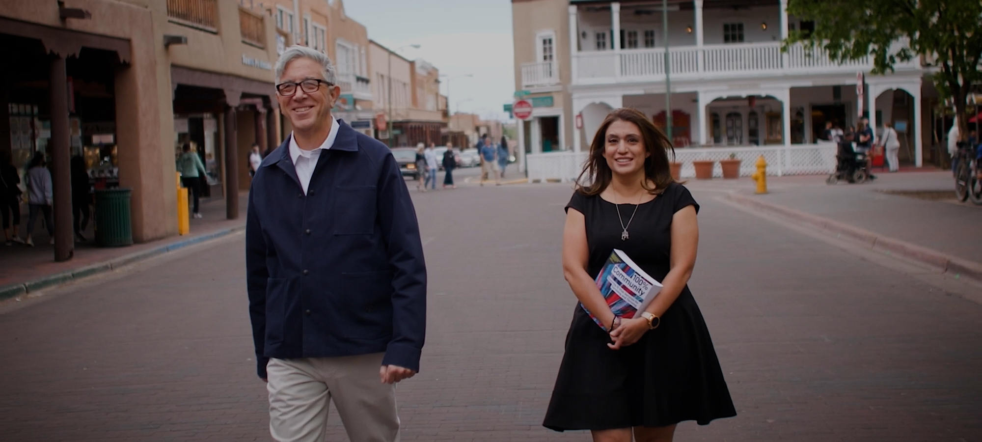 Katherine and Dom Two figures walk down a town street