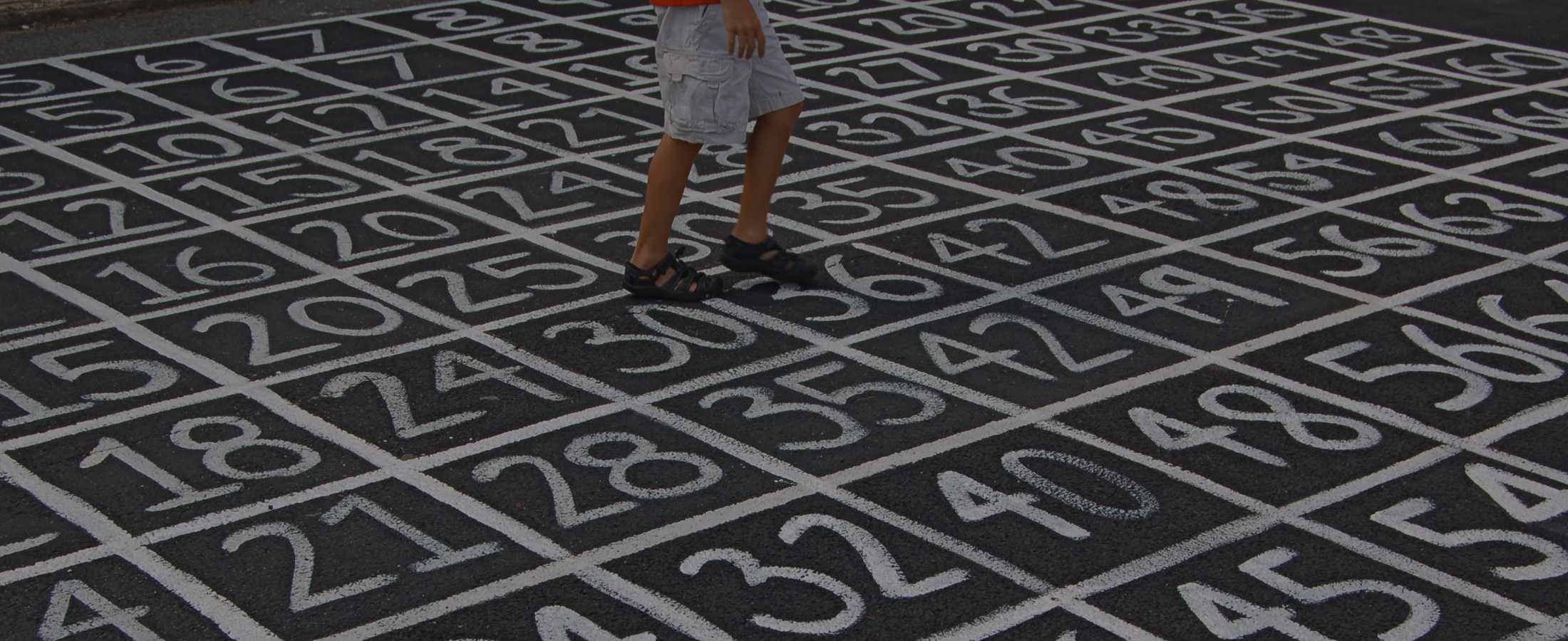 A child standing on numbers painted on the ground