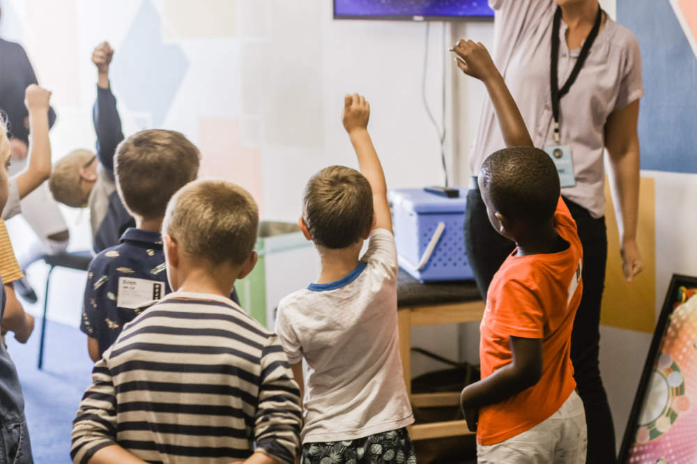 kids classroom raising hands ACEs scores in the classroom